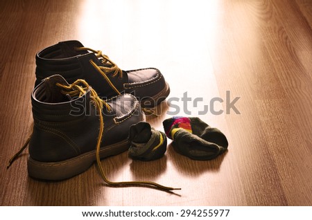 Still Life Dark Style of Vintage Brown Shoes with Sock Be in Confusion on Wooden Floor Background