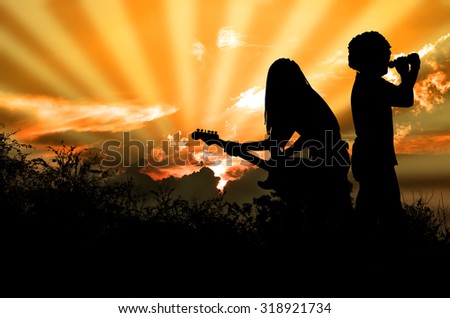 Music for the Earth Rocker and Guitarist are Singing and Playing Rock Music Against the Background of Orange Sky