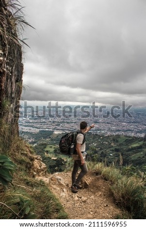 male hiker pointing his hand towards the capital city of San Jose in Costa Rica