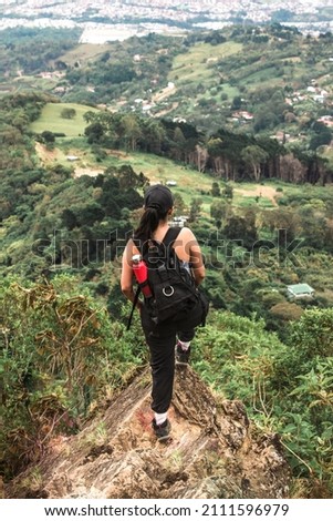 female hiker with backpack contemplating the view to the capital city of San Jose in Costa Rica