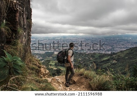male hiker contemplating the capital city of San Jose in Costa Rica