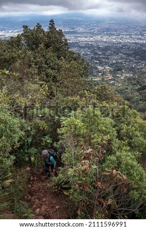 hiker walking up a path overlooking the capital city of San Jose in Costa Rica