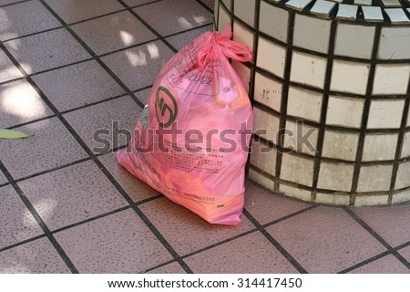 New Taipei City, Taiwan - Sep. 8, 2015: A bag of garbage on the outside on the ground