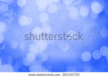 Water droplets on the glass with a colored background. Drips of water.