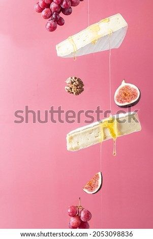 Flying cheese. Brie cheese with honey on a pink background.  Сток-фото © 