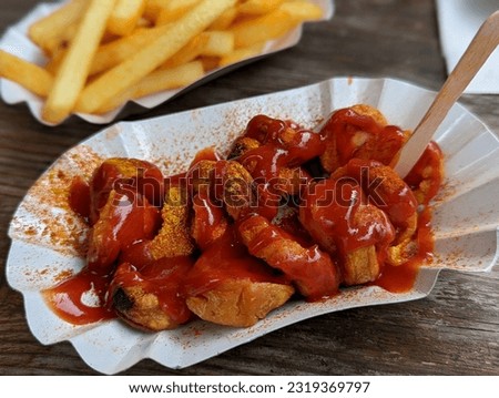 Similar – Image, Stock Photo German Currywurst sausage with curry ketchup, roasted onions and French fries with mayonnaise in the city