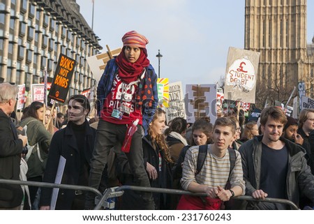 LONDON, ENGLAND - NOVEMBER 19: Students take part in a protest march against fees and cuts in the education system on November 19, 2014 in London, England. Protestant on the fence.