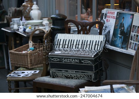 London - January 17, 2015. Flea market with old-fashioned goods displayed in London city, UK.  On 17 January 2015. Messy packed room full of antique objects like dolls, accordion, wicker