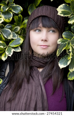 portrait young attractive pensive woman wearing cap standing in bush