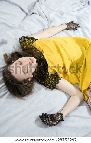 young cute woman in vintage yellow dress sleeping  on bed
