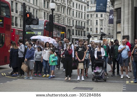 LONDON - AUG 10 : Crowd passing oxford circus on Aug 10, 2015, London, UK. Oxford Circus, busy intersection with Regent Street, is biggest shopping street in Europe, visited by millions of tourists