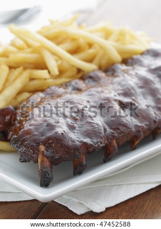 baked ribs with french fries on the side. Meat meal.