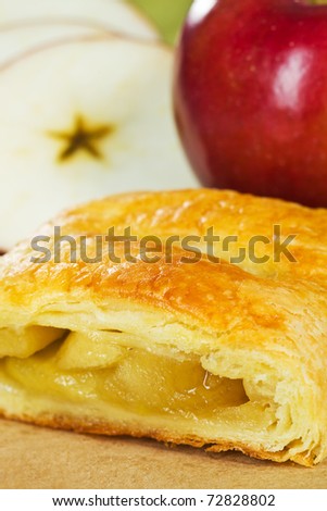 Apple turnover with fruit in the background. Very shallow depth of field.