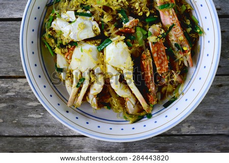 Thai Food (Boo Pad Pong Karee) : Sea Crab  stir fried  in Yellow Curry with Coconut Milk and cellophane noodle on wooden table