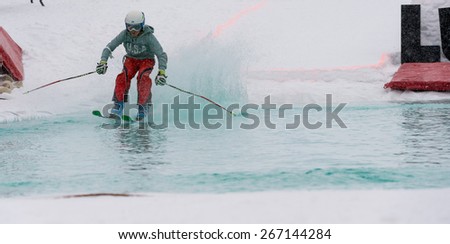 Unknown ski rider jumps into the pool with ski equipments in the Luza (puddle), Krvavec, Slovenia - April 4, 2015