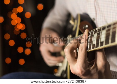 Practicing in playing guitar. Handsome young man playing guitar