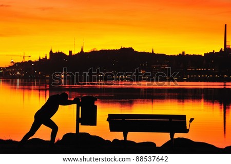 View of the skyline of Stockholm with the south of the city in the background and a stretching jogger in the foreground.