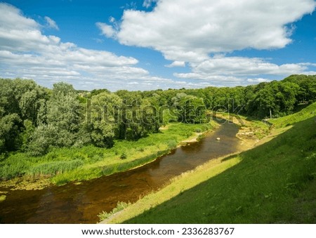 Similar – Foto Bild Kleiner Fluss in einem lettischen Wald, aufgenommen von einer Brücke. Das Wasser ist mit Wasserpflanzen bewachsen, viele Grüntöne und einige Gelbtöne. Frühherbst Landschaft, bewölkten grauen Himmel