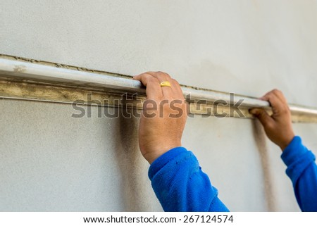 builder worker plastering facade house building with putty knife float
