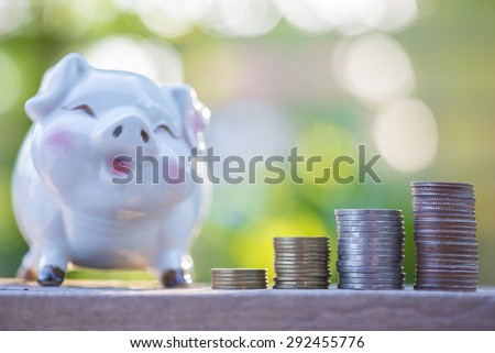 increasing stack of money coins and piggybank, saving money.