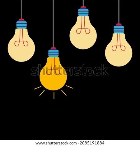Light bulbs hanging on a set of incandescent filaments. One glows the brightest on a black background.