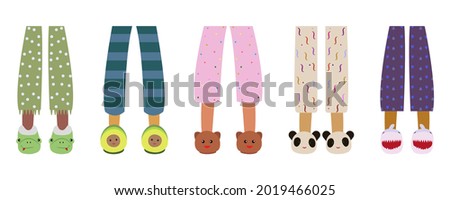 Children in pajamas with funny slippers. Children's feet in animal slippers. Home footwear slippers. Pajama party, children's holiday. 