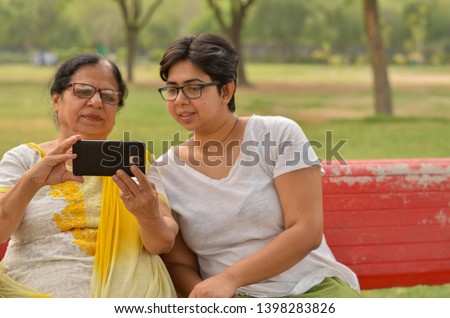 Similar – Image, Stock Photo Adult daughter teaching her elderly mother to use laptop