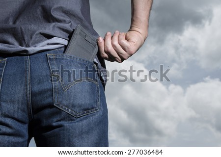 man keeping your wallet in the back pocket of his blue jean sky background