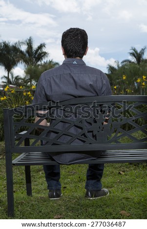 Man sitting on chair back looking at the landscape park