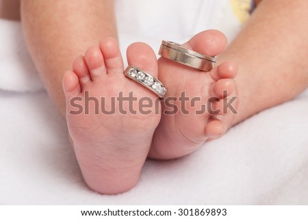Baby feet with wedding rings parents