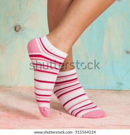 beautiful legs woman with socks standing on tiptoe on the wooden floor