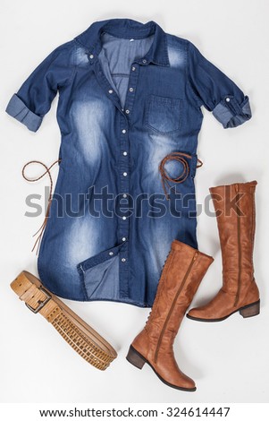 indigo fabric dress with buttons, belt and brown boots on white background