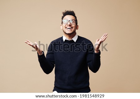 Portrait of an excited Afro casual man standing with raised hands and looking at camera isolated on a beige background Foto stock © 