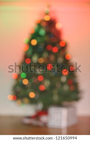 One gift under a Christmas tree all out of focus