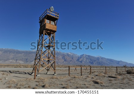 Guard tower with a search light in the desert by the mountains