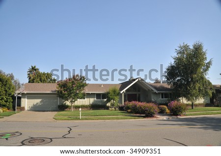 House with nice  landscaping, trees, mailbox, basketball hoop