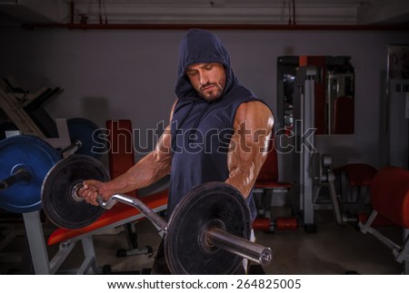 Body Builder performing barbell curls exercise.