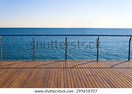 Empty ocean viewpoint platform with wooden floor desk. Clear sky and blue sea in a sunny day of summer. Horizontal composition.