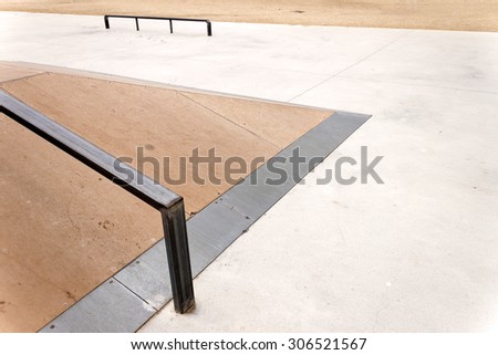 Detail of a wooden jump box with metal rail for grind skate tricks in an empty skate-park. Copy-space for placing text.