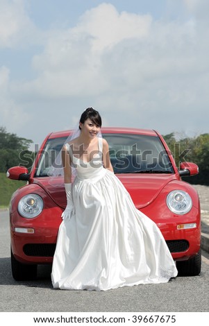 Bride poses in front of sport car