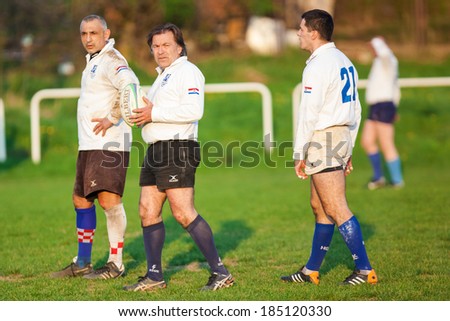 ZAGREB, CROATIA - MARCH 29, 2014: Friendly rugby match RC Zagreb Old Lions in white jersey (CRO) and Reigate RFC in blue jersey (UK). Unidentified Zagreb players with ball.