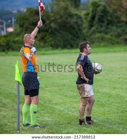 ZAGREB, CROATIA - SEPTEMBER 13, 2014: Croatian Rugby league - RC Zagreb Old Lions (white jersey) VS RC Sinj (dark blue jersey). Referee holding the flag