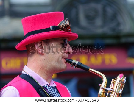 EDINBURGH, SCOTLAND - AUGUST 15, 2015: Male musician from The Ambling Band playing the saxophone at the Grassmarket during the Edinburgh International Fringe Festival