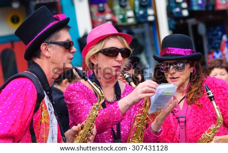 EDINBURGH, SCOTLAND - AUGUST 15, 2015: Male and female musicians from The Ambling Band all playing the saxophone at the Grassmarket during the Edinburgh International Fringe Festival