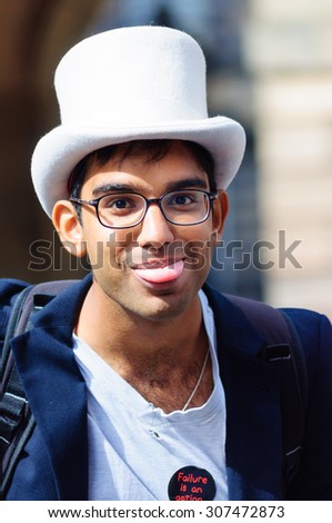 EDINBURGH, SCOTLAND - AUGUST 15, 2015: Male performer wearing a top hat and sticking his tongue out on the Royal Mile during the Edinburgh International Fringe Festival
