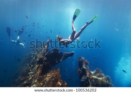 Young woman diving on a breath hold and fining in blue transparent sea near wreck USAT Liberty, Tulamben, Indonesia