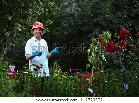 Mature caucasian happy man caring of green garden and flowers
