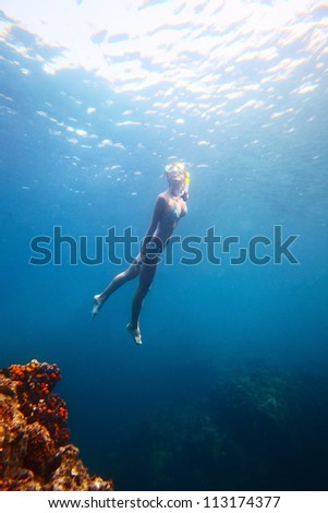 Young woman diving on a breath hold in a tropical sea