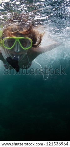 Close up underwater portrait of a woman in mask making bubbles