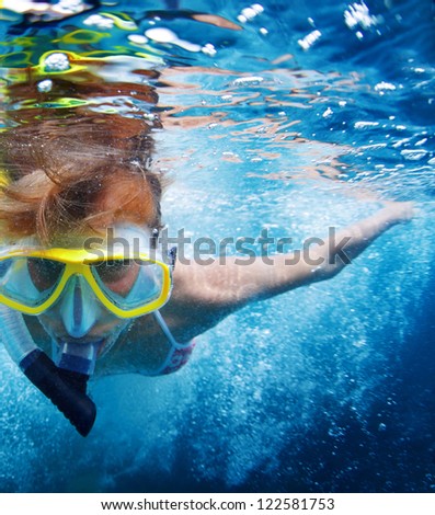 Close up underwater portrait of a woman in mask making bubbles in a sea